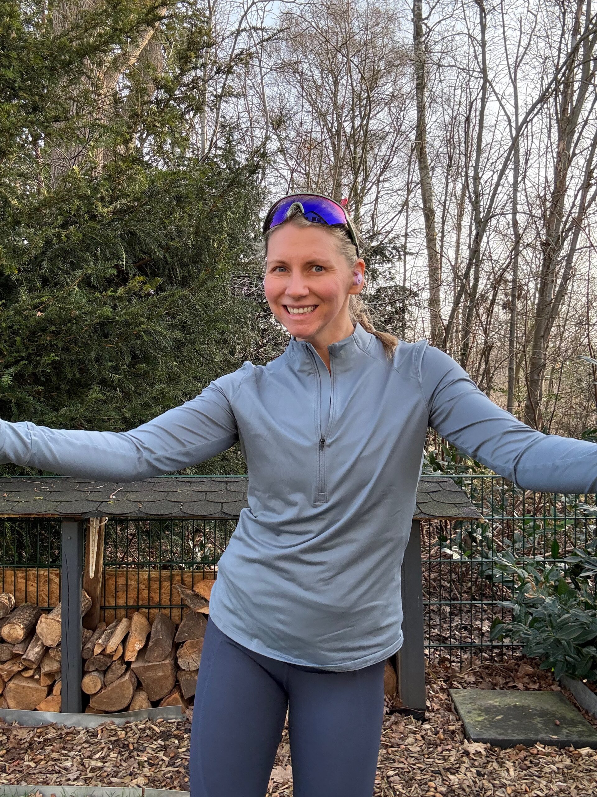 Coach Mandy in a blue running jacket with arms stretched wide