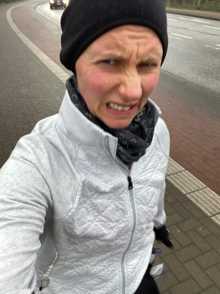 Coach Mandy on a cold, rainy run in a jacket and beanie