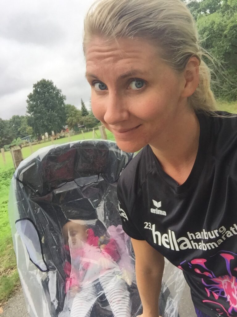 Coach Mandy smiling next to a running stroller
