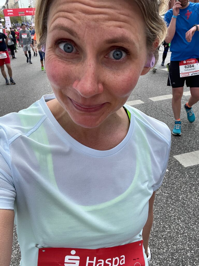 Coach Mandy smiling with a race bib during a race