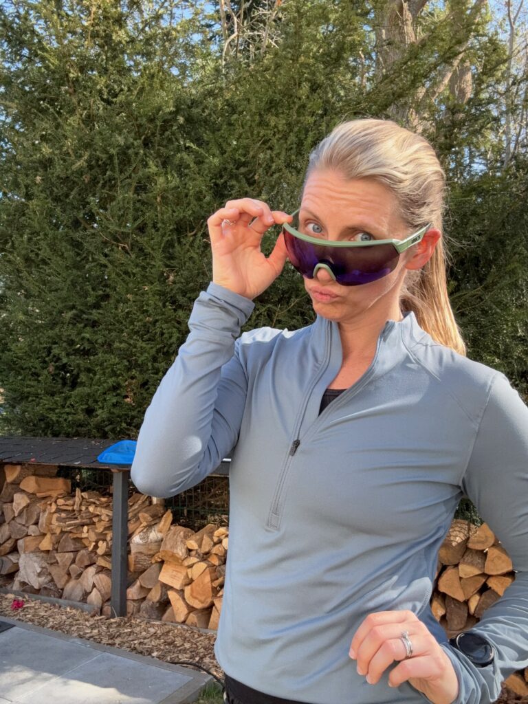 Coach Mandy lifting her sunglasses and smiling outdoors