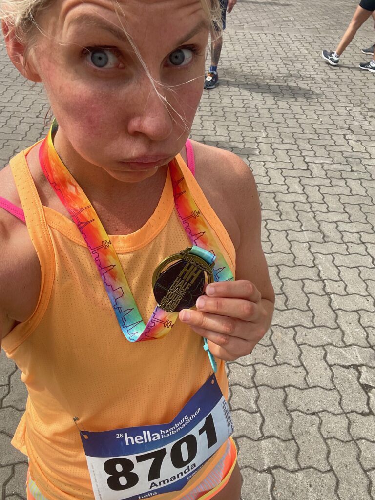 Coach Mandy showing her finisher medal after a race