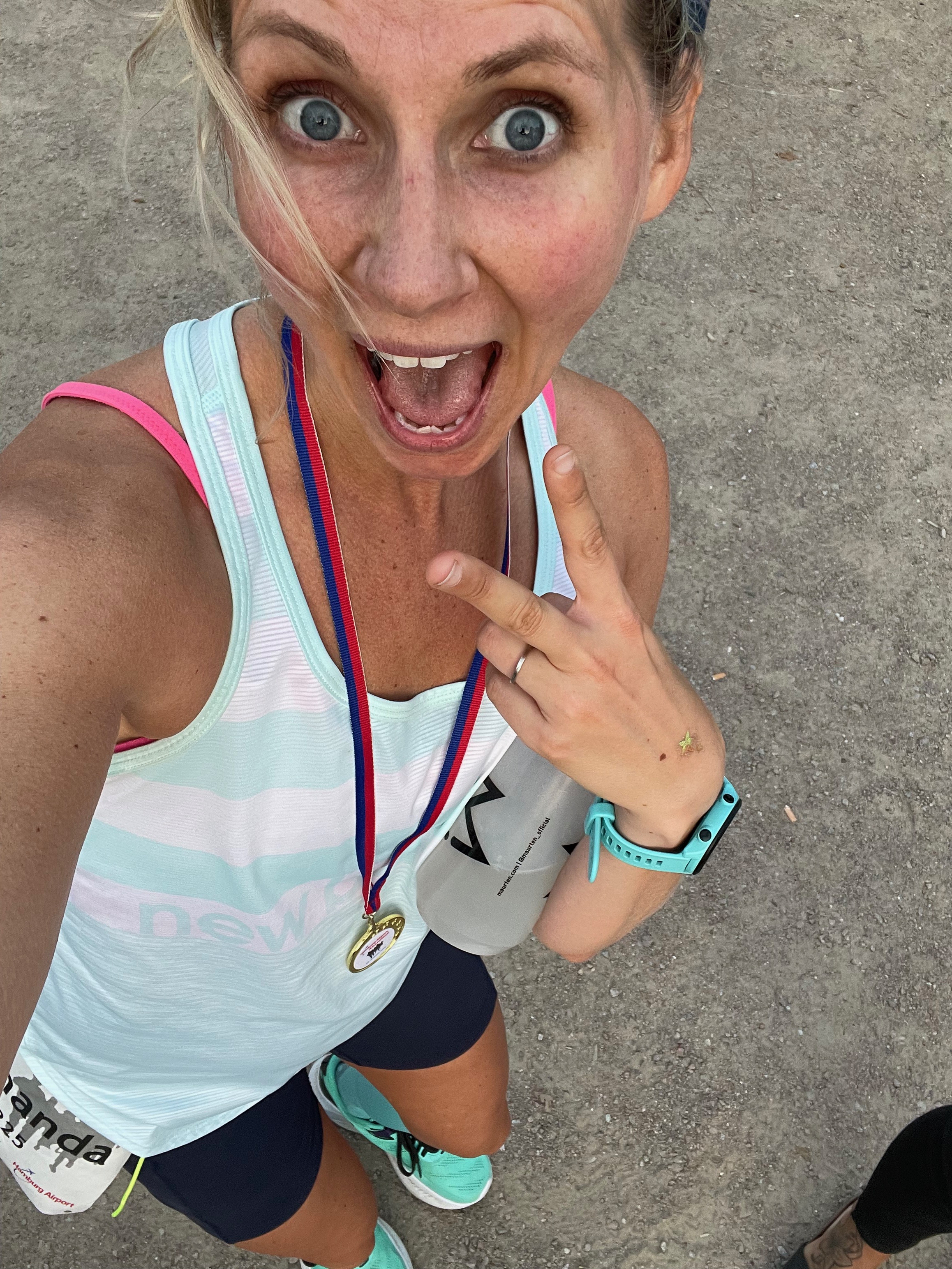 Coach Mandy smiling with a finisher medal after a run