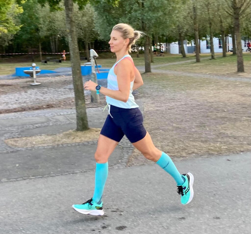 Coach Mandy running along a park path