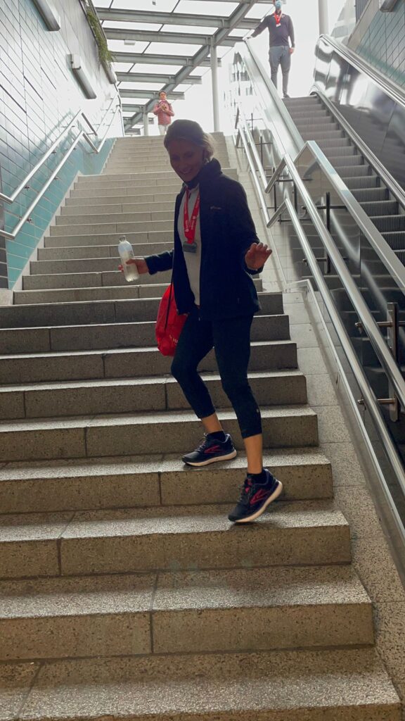 Coach Mandy running up a flight of stairs